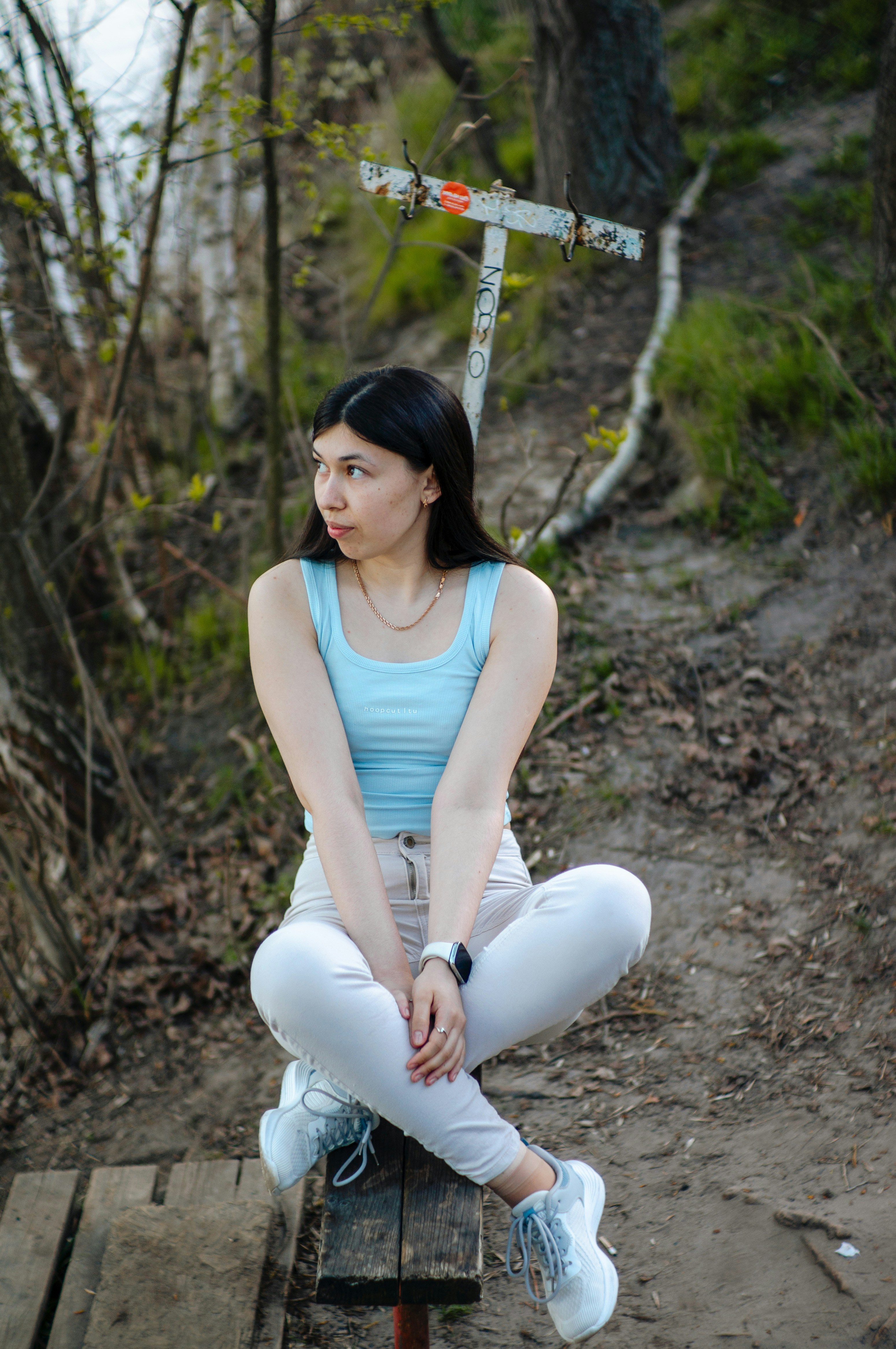 Eine junge Frau sitzt im Freien und posiert.