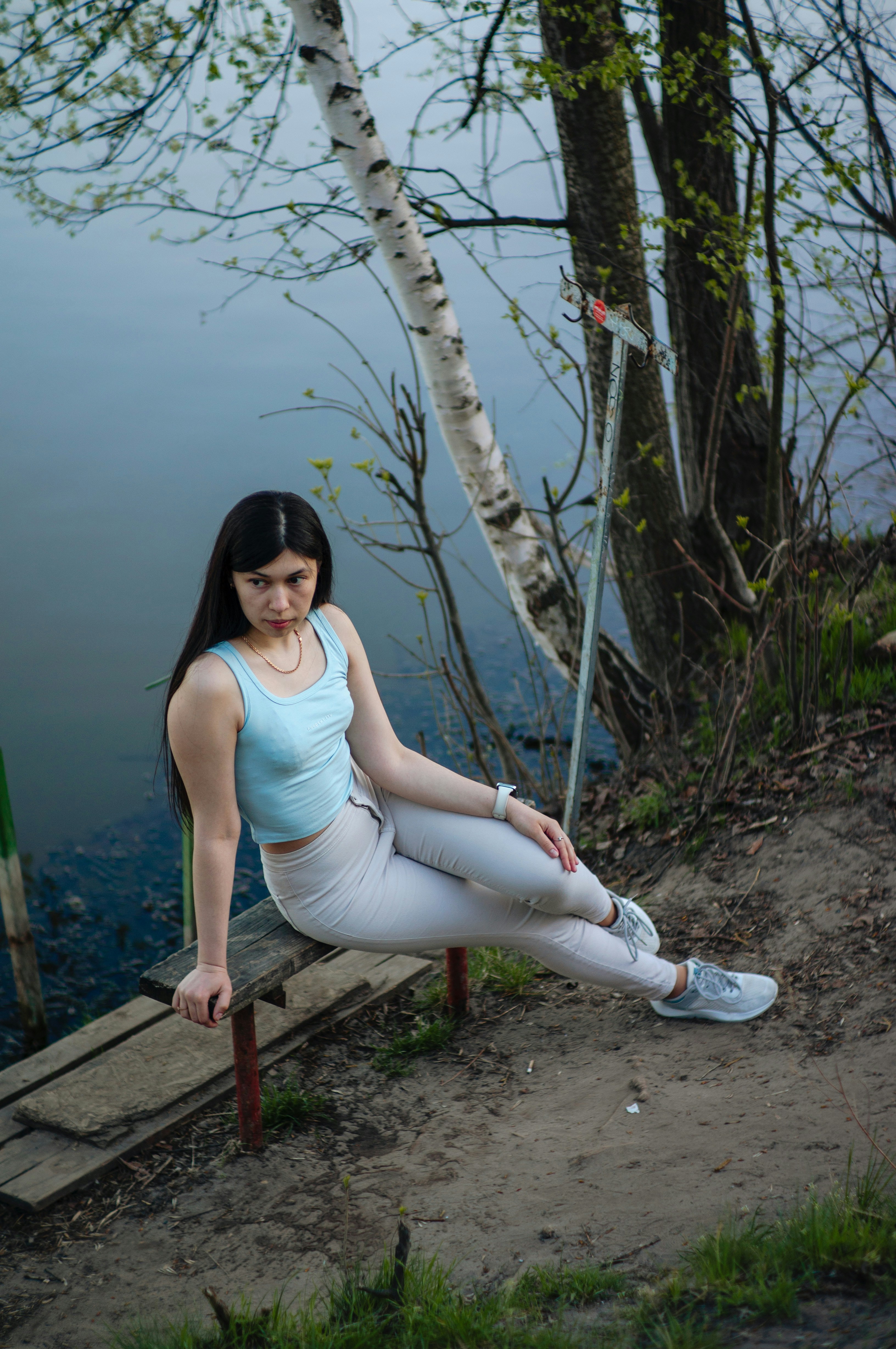 Eine Frau posiert an einem ruhigen See.