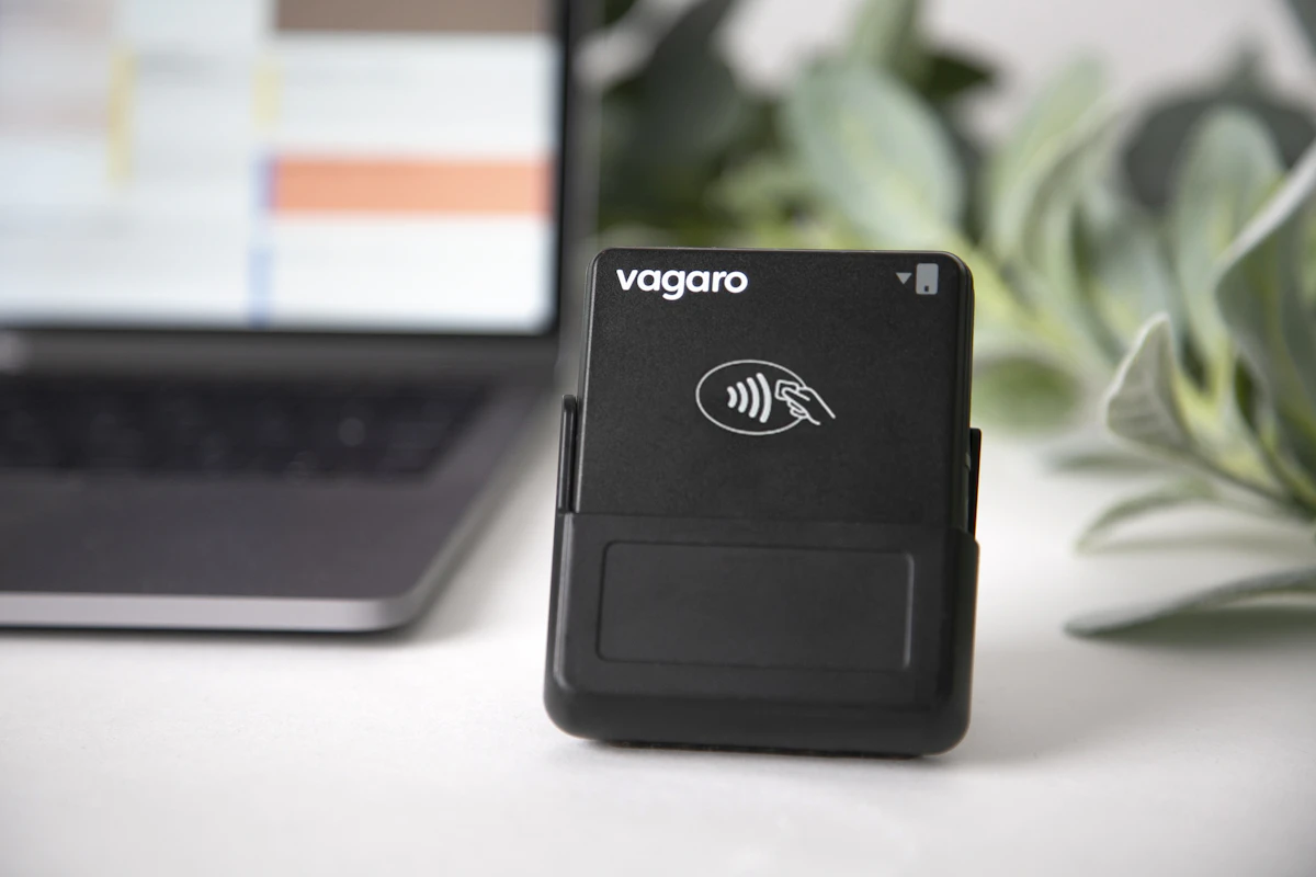 A vagaro card reader sits next to a laptop