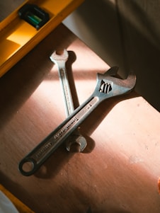 Wrenches and level rest on a wooden surface.