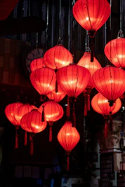Red lanterns illuminate a dark room.