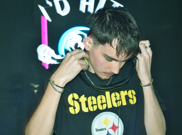 A man wearing a steelers shirt adjusts his hood.