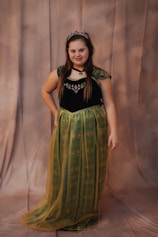 A young girl in an anna costume smiles.