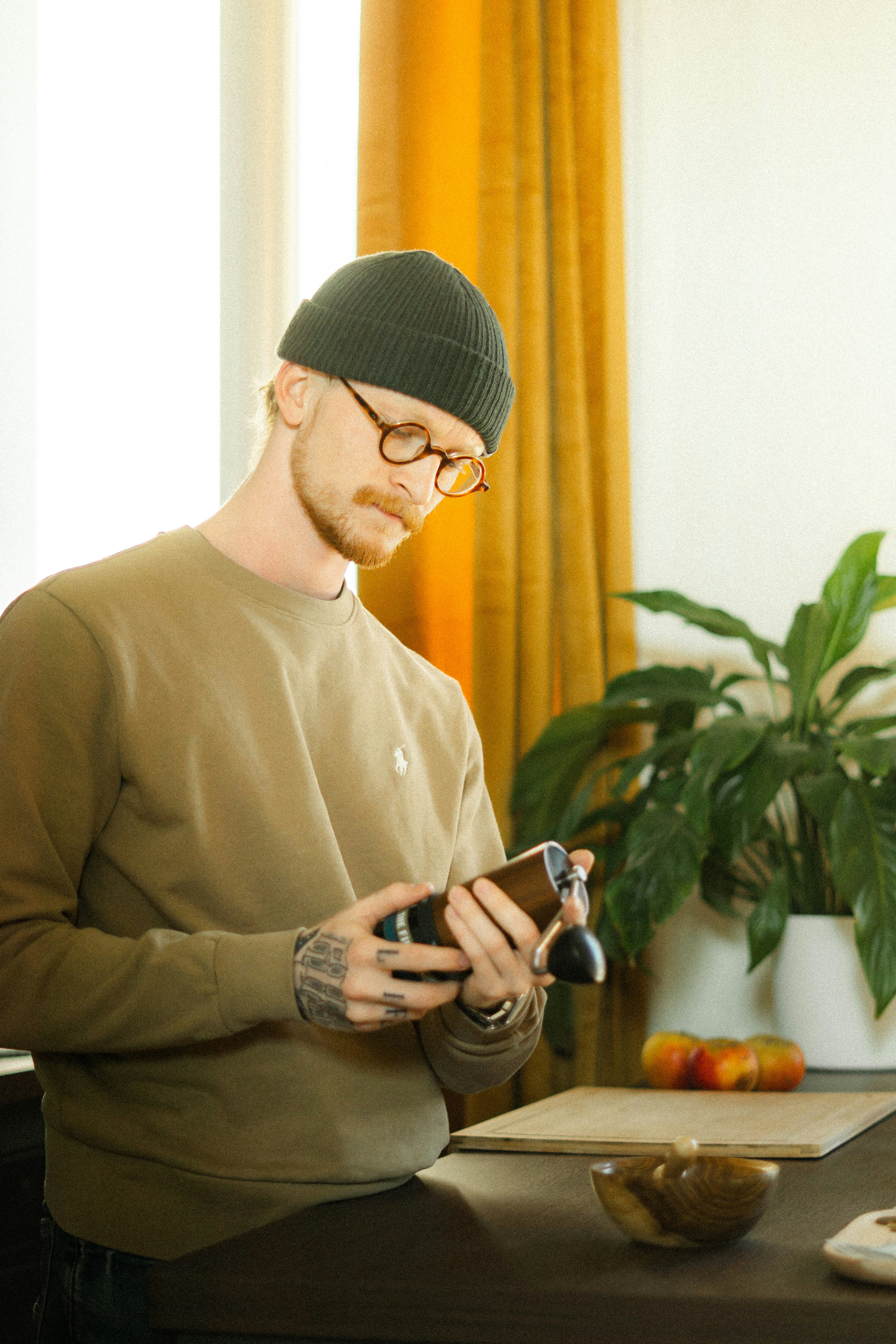 A man is grinding pepper in the kitchen.