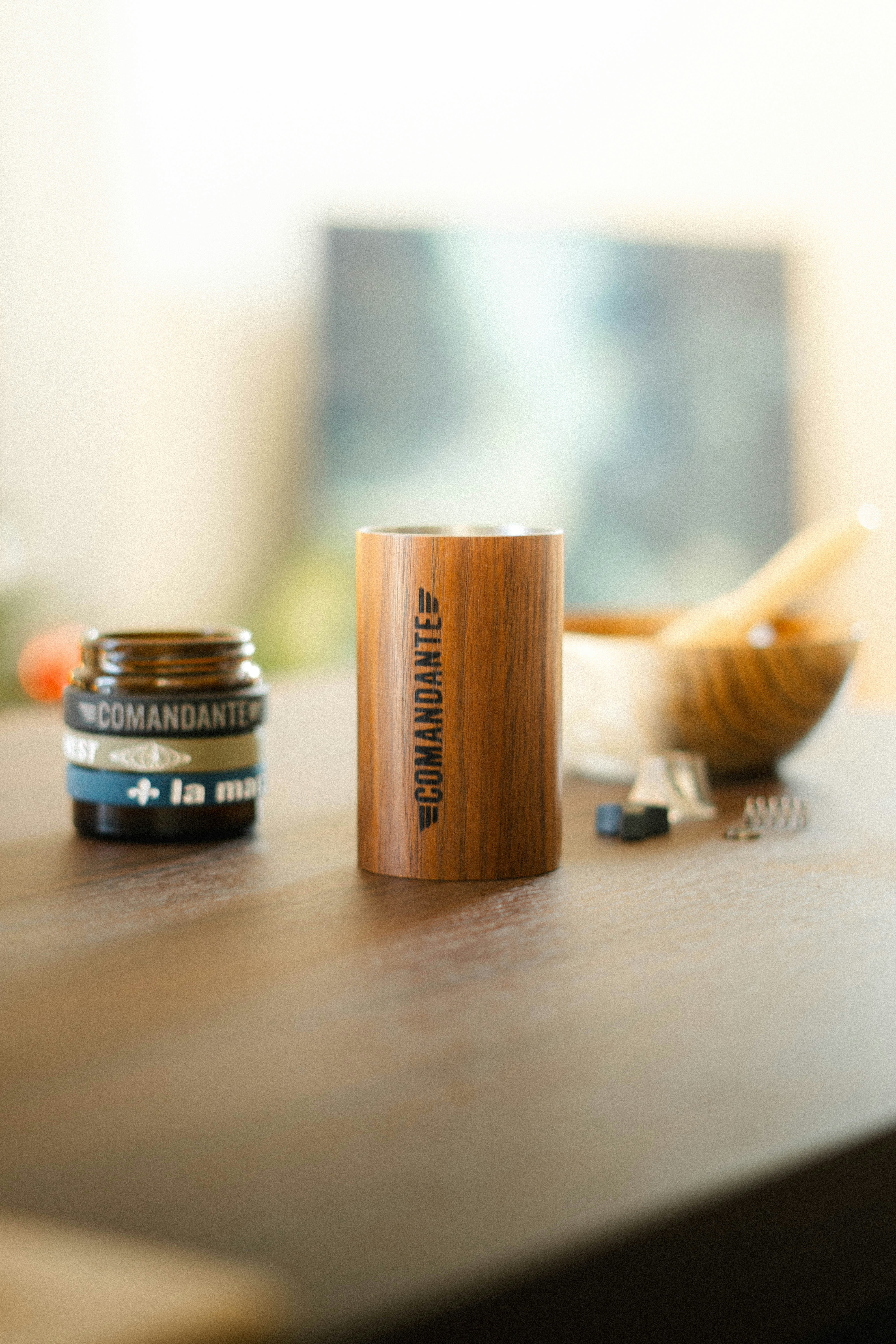 Comandante coffee grinder and accessories on a table.