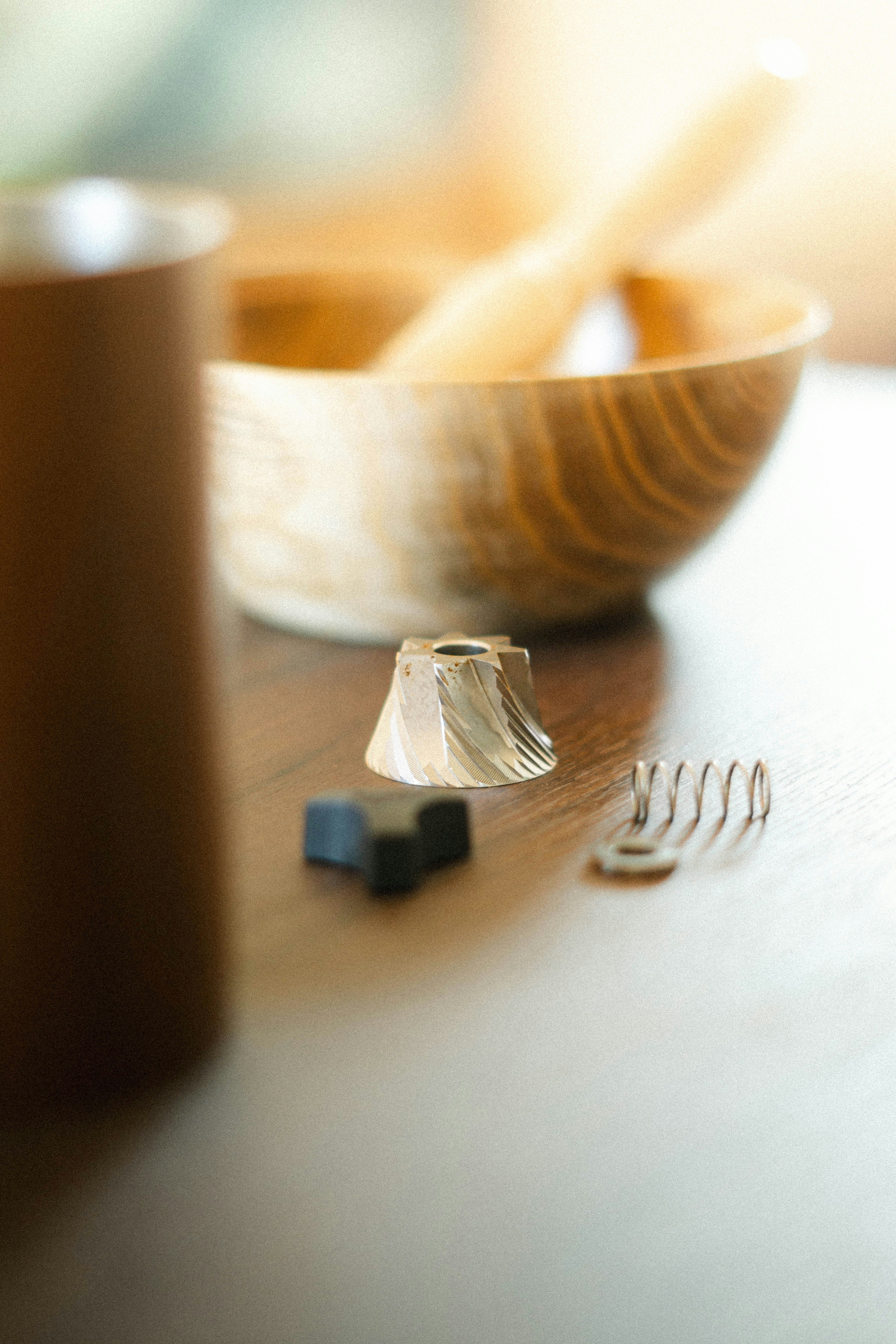 Parts of a coffee grinder sit on a table.