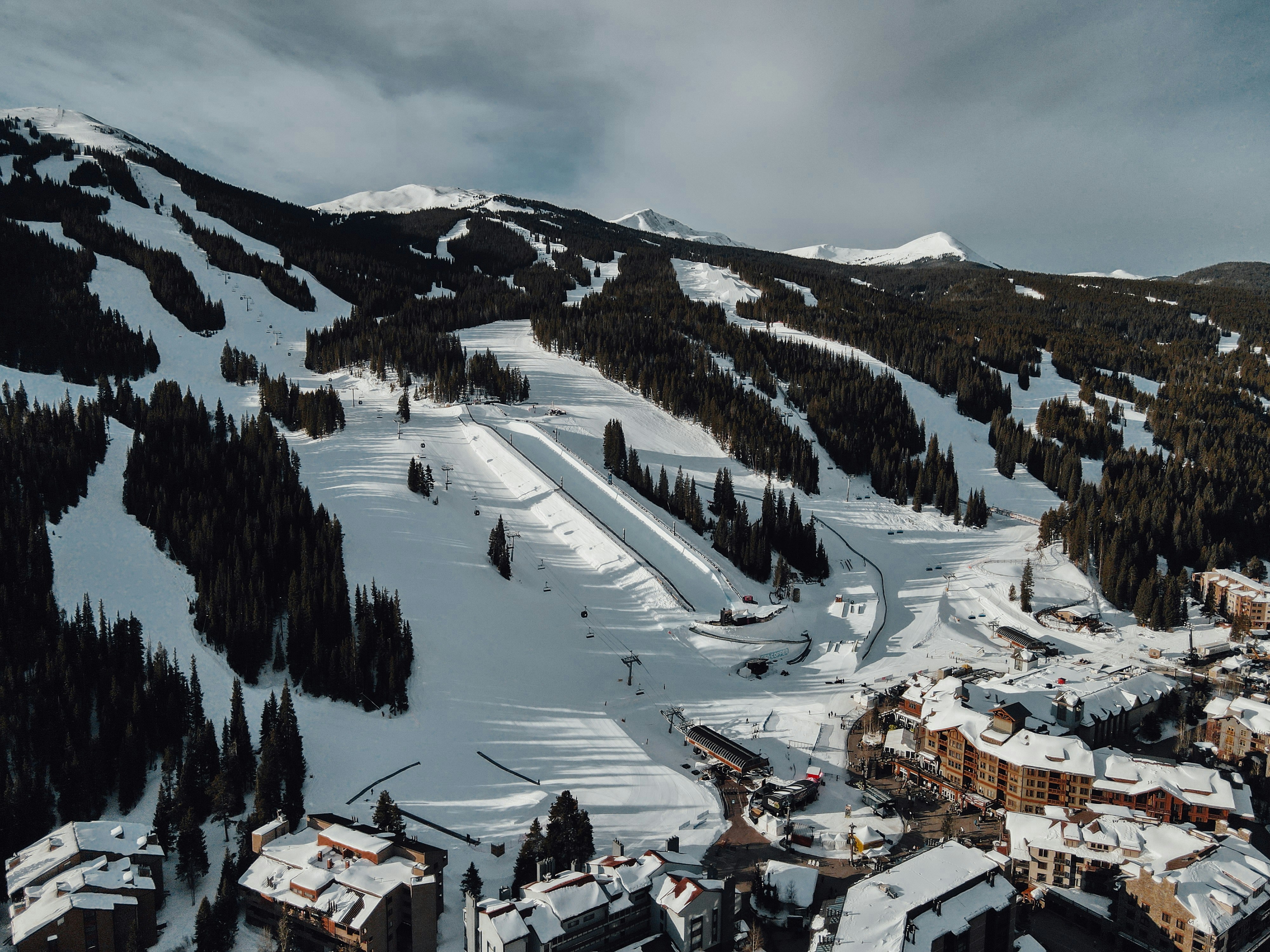 A snowy mountain with ski slopes and buildings.