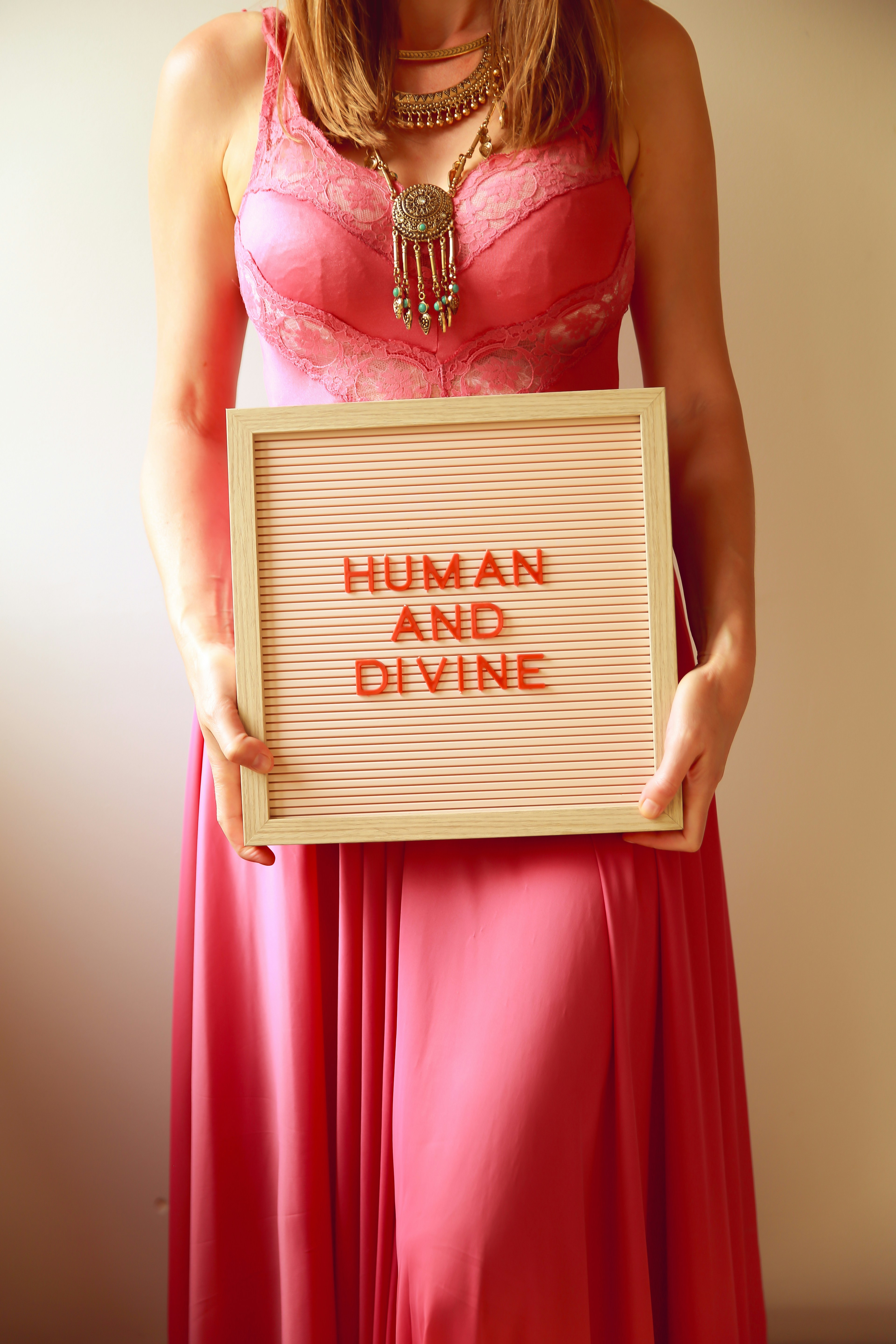 Die Frau hält ein Schild mit der Aufschrift "menschlich und göttlich".