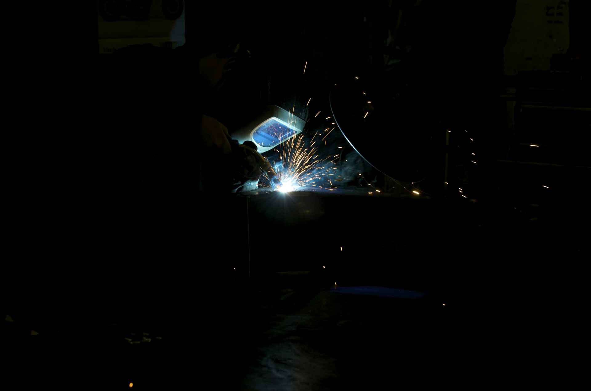 Welding sparks illuminate the darkness.