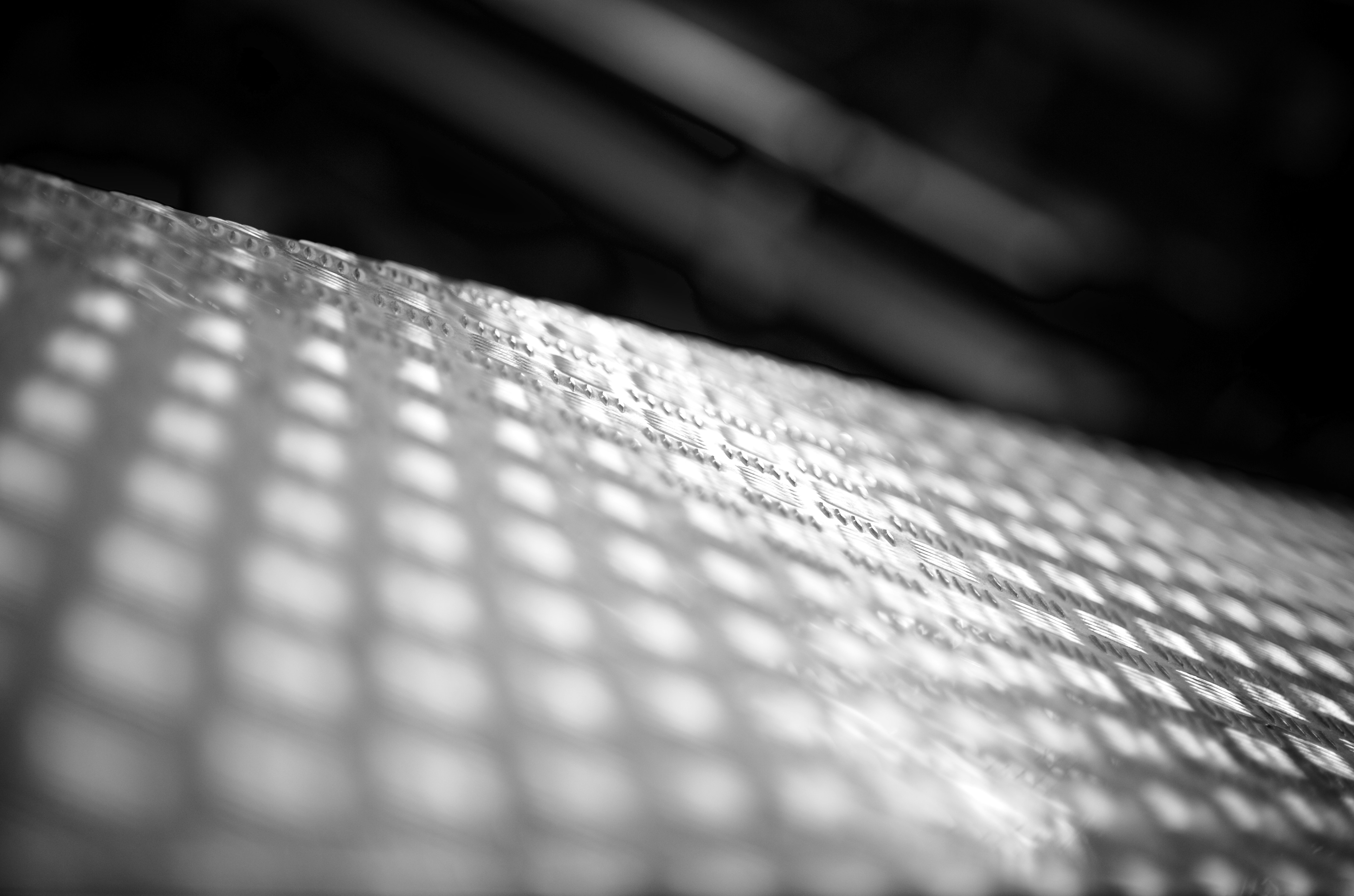 A gridded surface casts shadows in black and white.