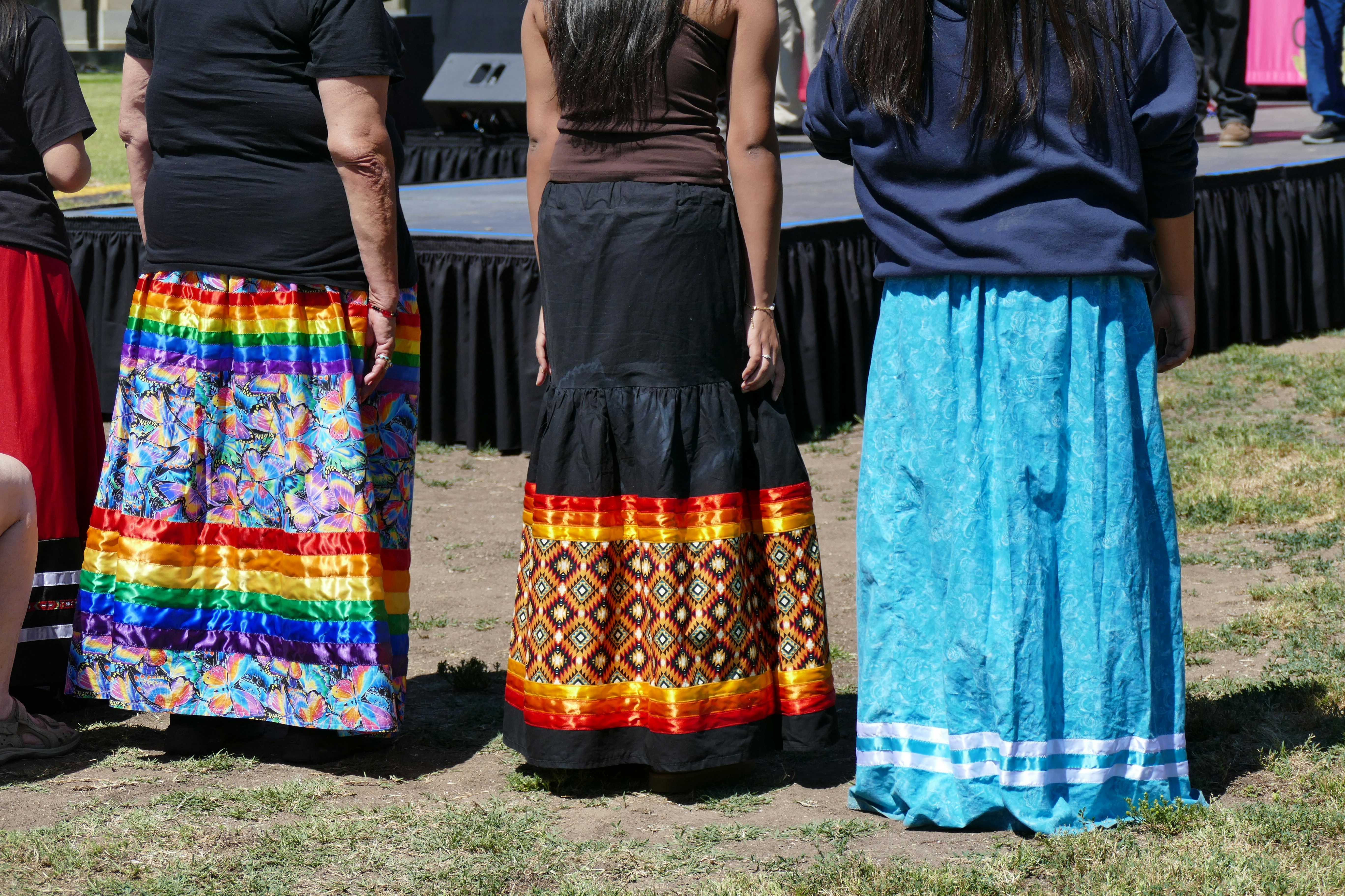 People are wearing colorful traditional skirts.