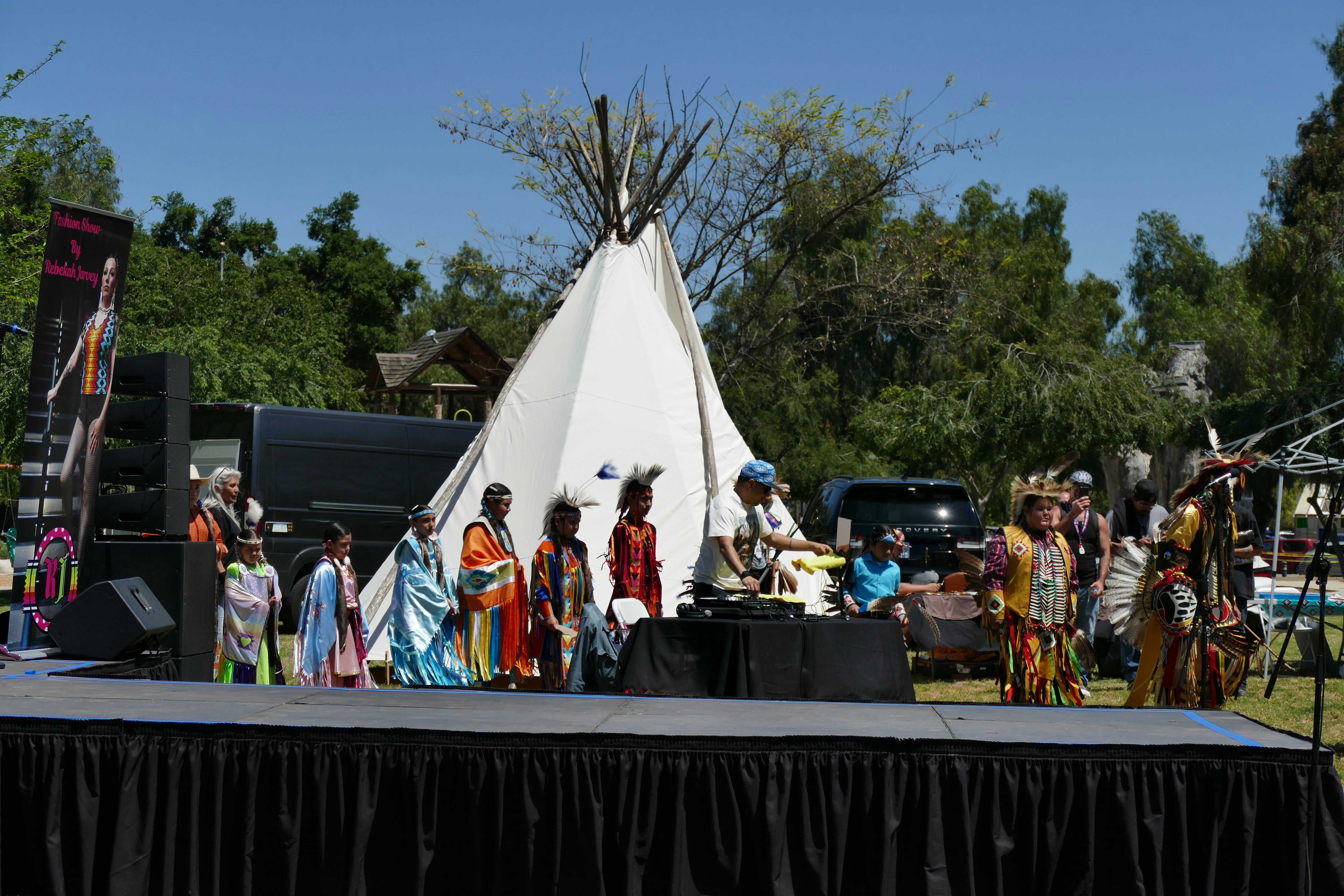 People are performing a cultural dance on stage.