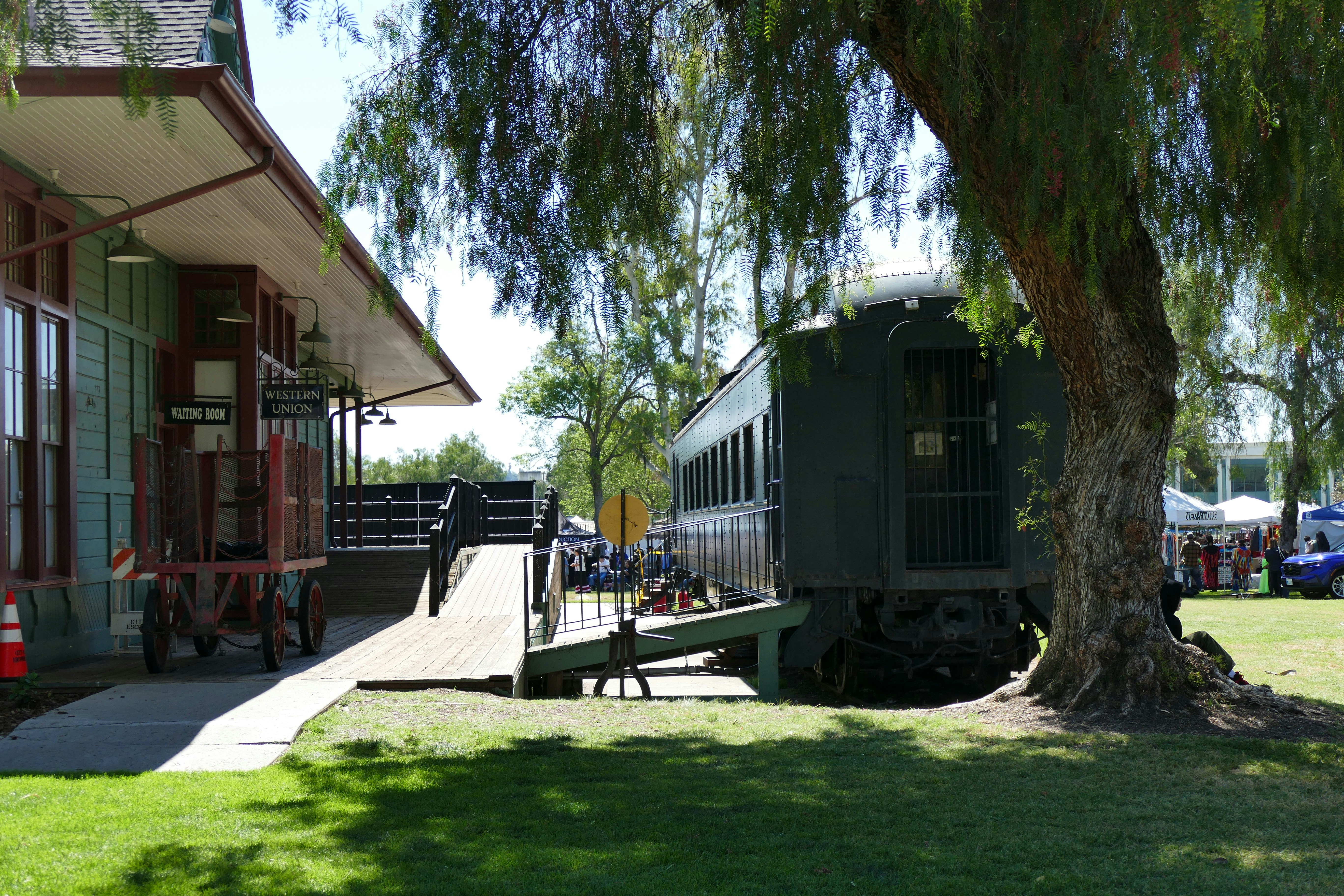 An old train car sits near a train station.