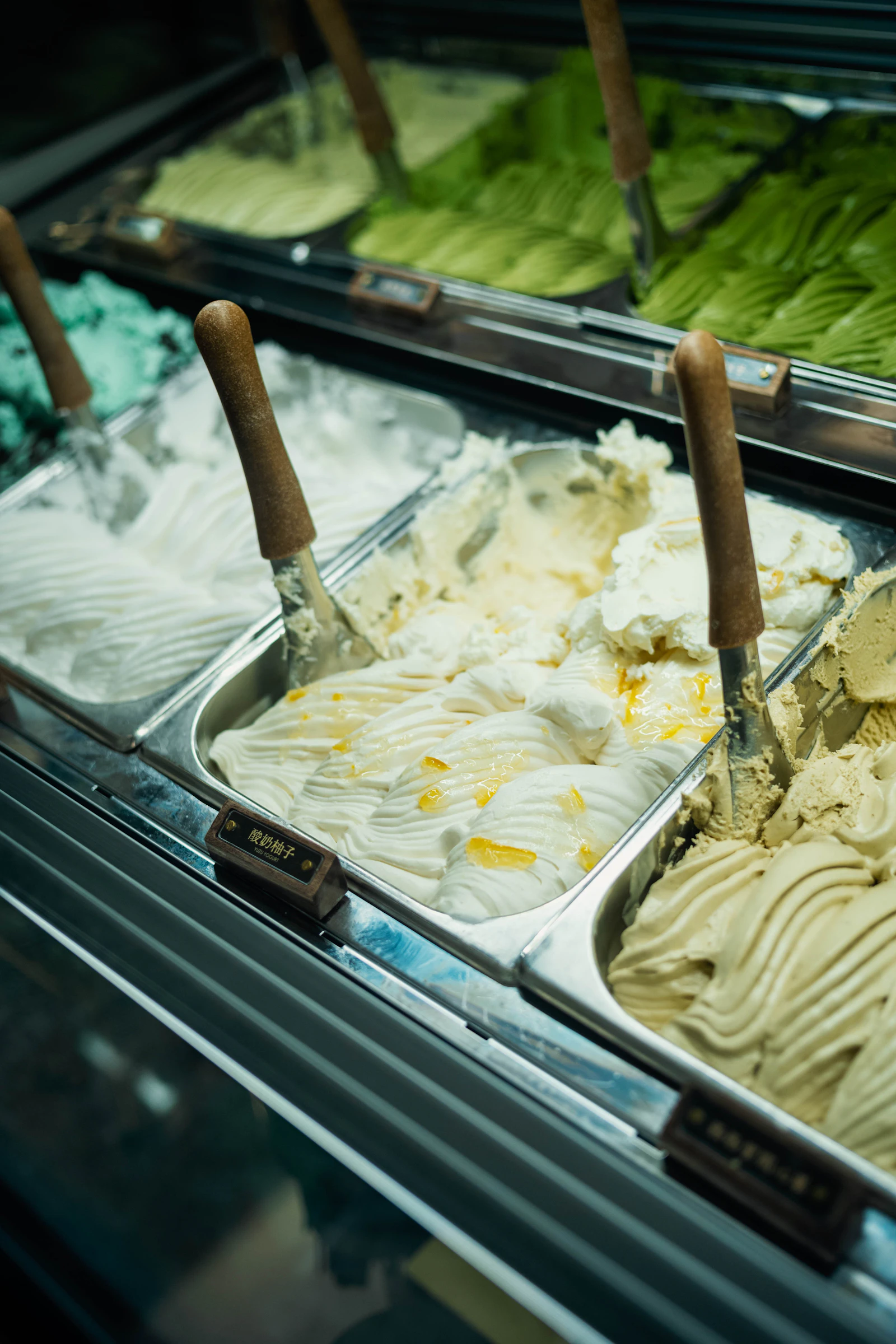 Rows of colorful gelato flavors in a chilled display case
