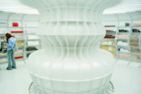 A futuristic, all-white store with shelves.