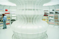 A futuristic, all-white store with shelves.