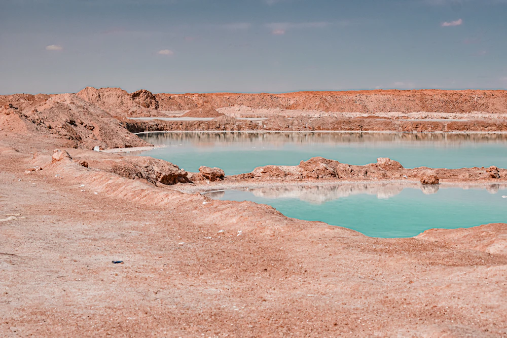 Turquoise salt pools cut into the white salt crust near Siwa