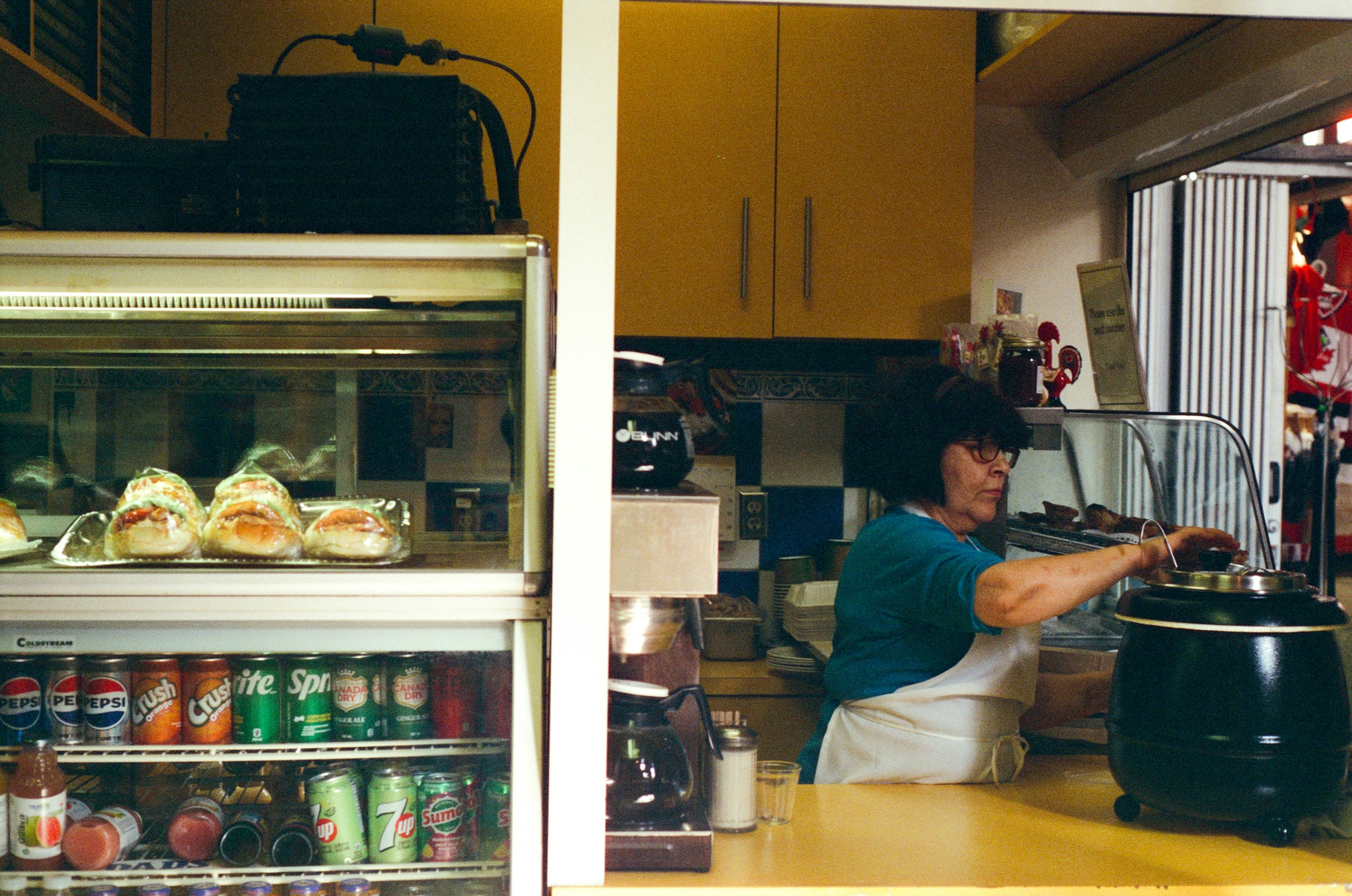 A woman prepares food behind the counter.
