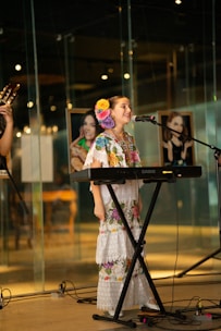 A girl sings while playing a keyboard.