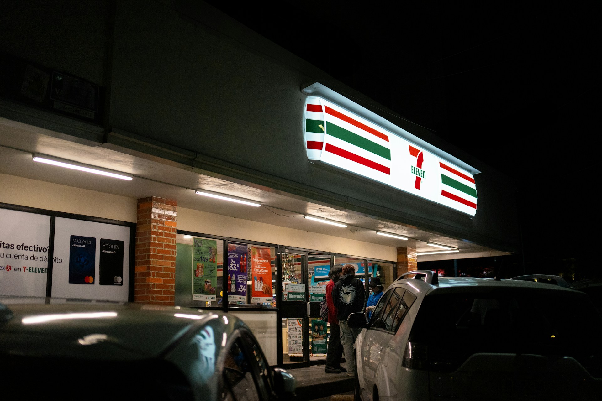 A 7-eleven store brightly lit at night.
