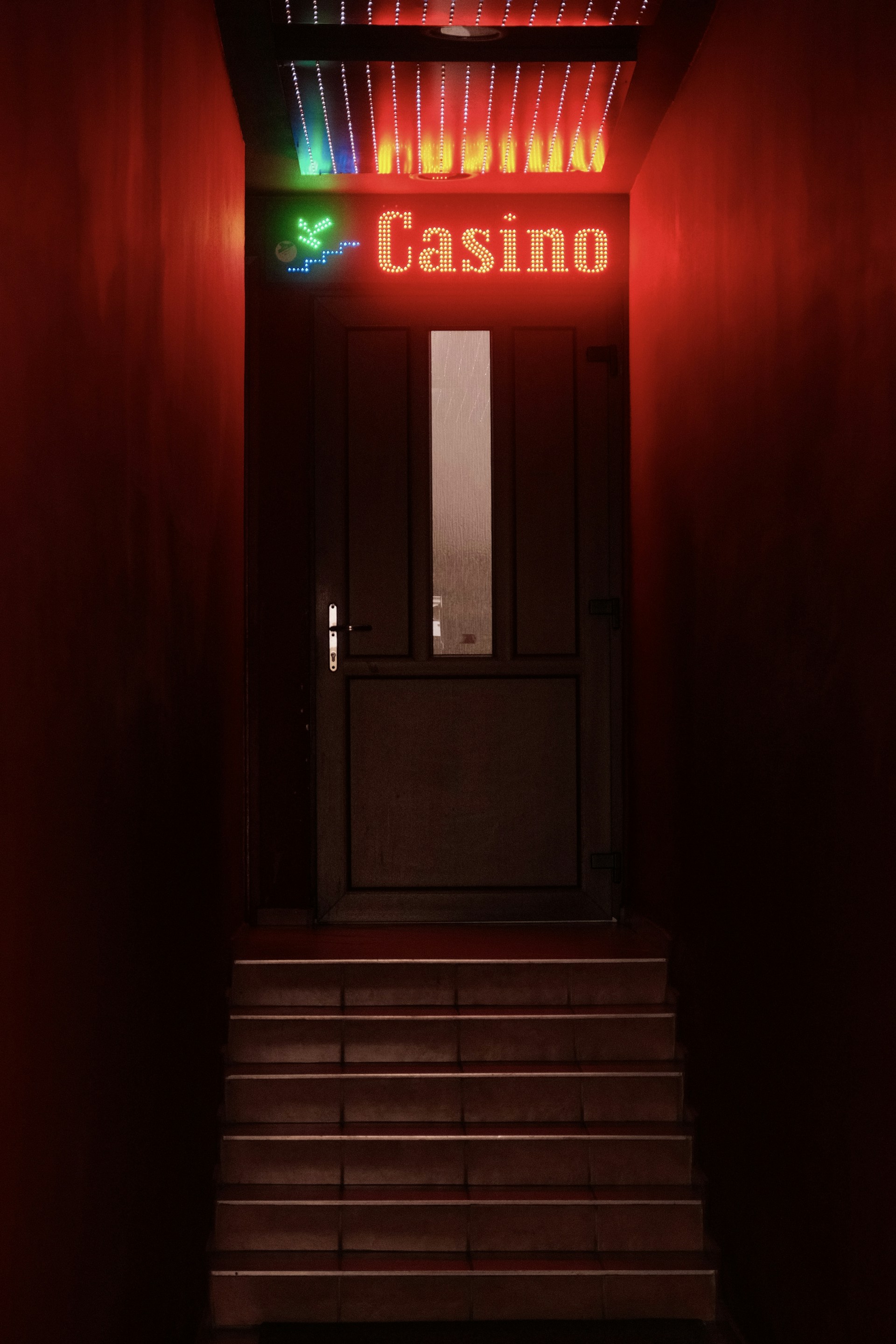 Casino entrance glowing with red neon lights.
