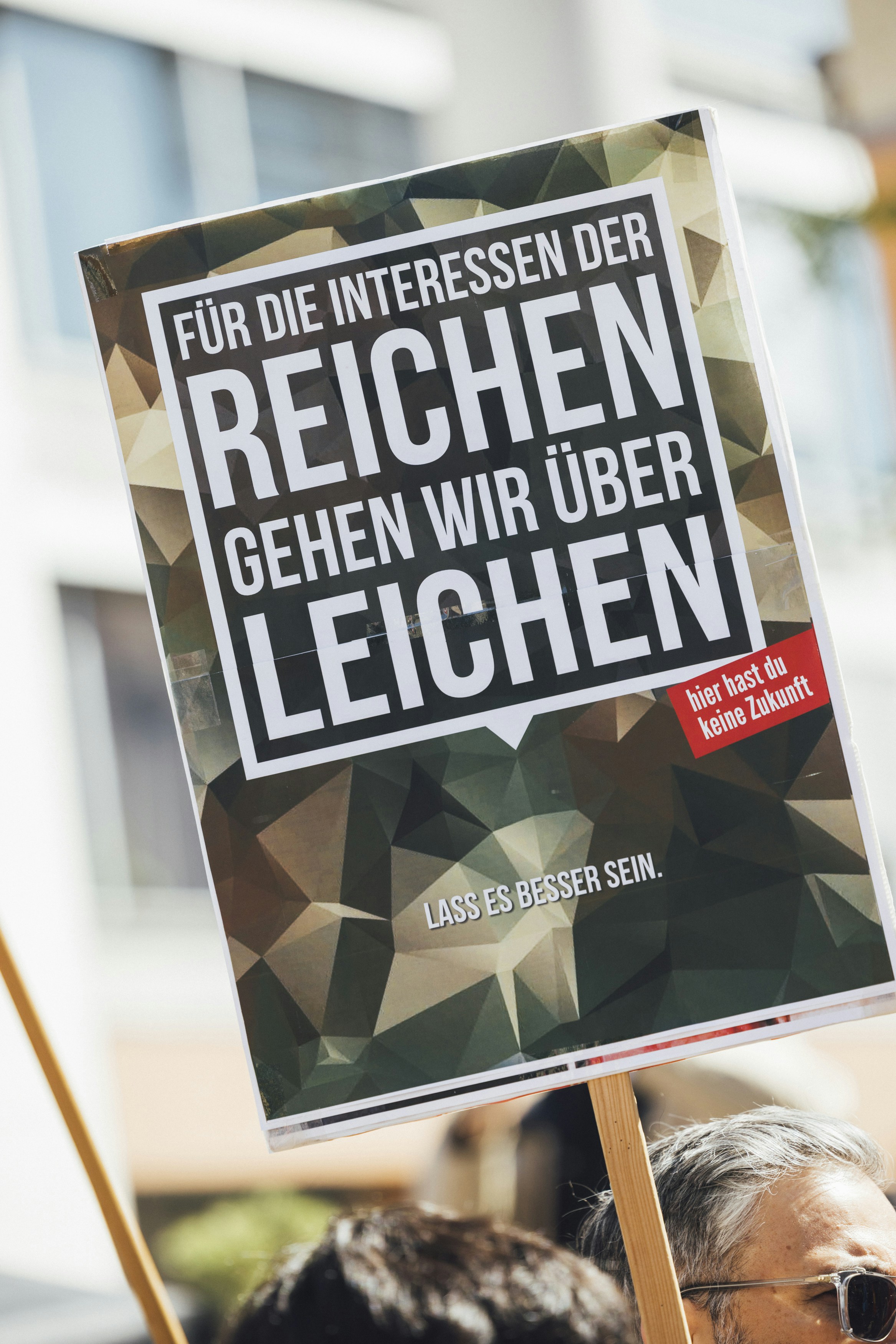 Protest sign: "we'll go over corpses for the rich."