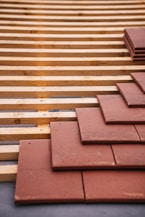 Roof tiles being installed on a wood structure.