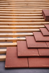 Roof tiles being installed on a wood structure.