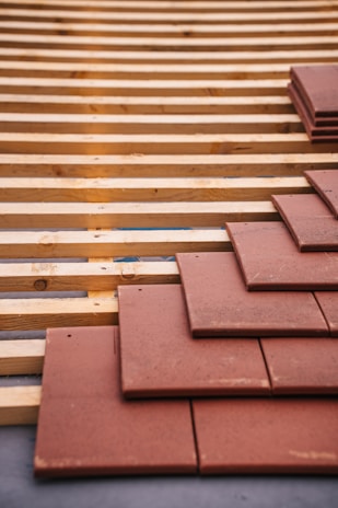 Roof tiles being installed on a wood structure.