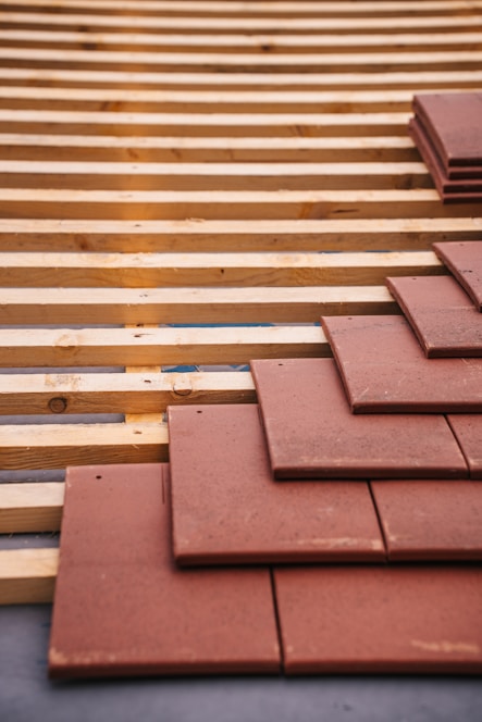 Roof tiles being installed on a wood structure.