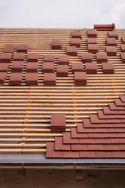 Roof tiles being laid on a wooden frame.