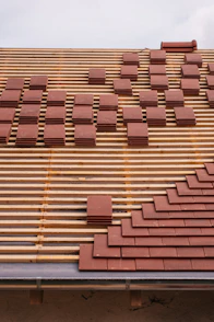 Roof tiles being laid on a wooden frame