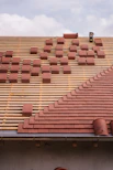 Roof under construction, with tiles being laid