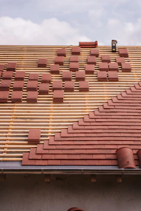 Roof under construction, with tiles being laid.