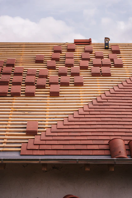 Roof under construction, with tiles being laid