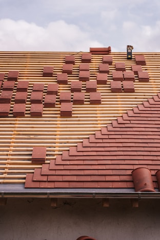 Roof under construction, with tiles being laid.