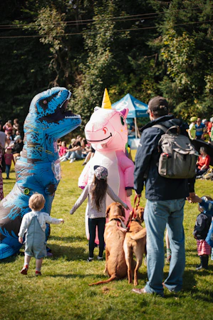 A dinosaur and unicorn attend a festival.