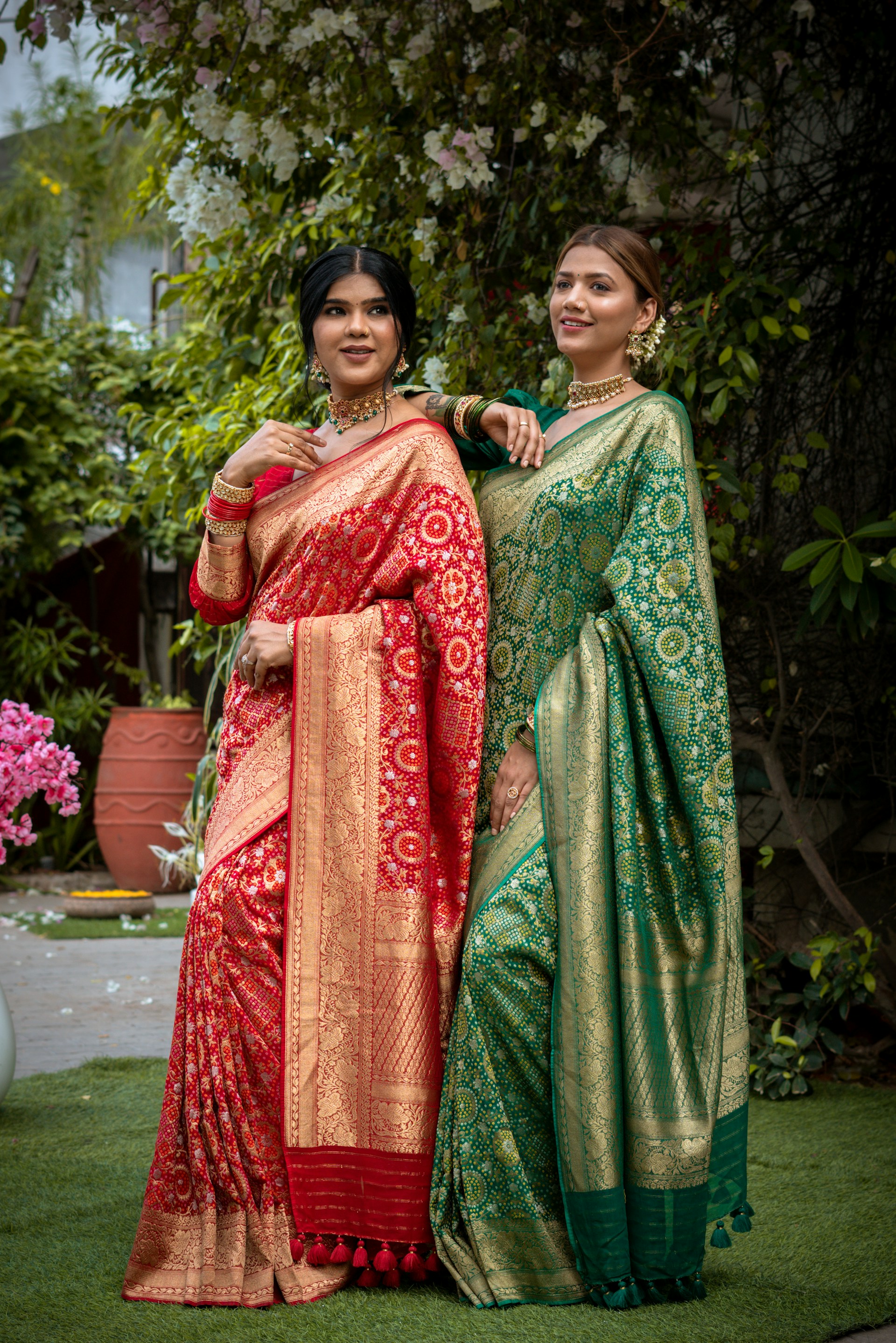 Two women pose in beautiful, traditional sarees.