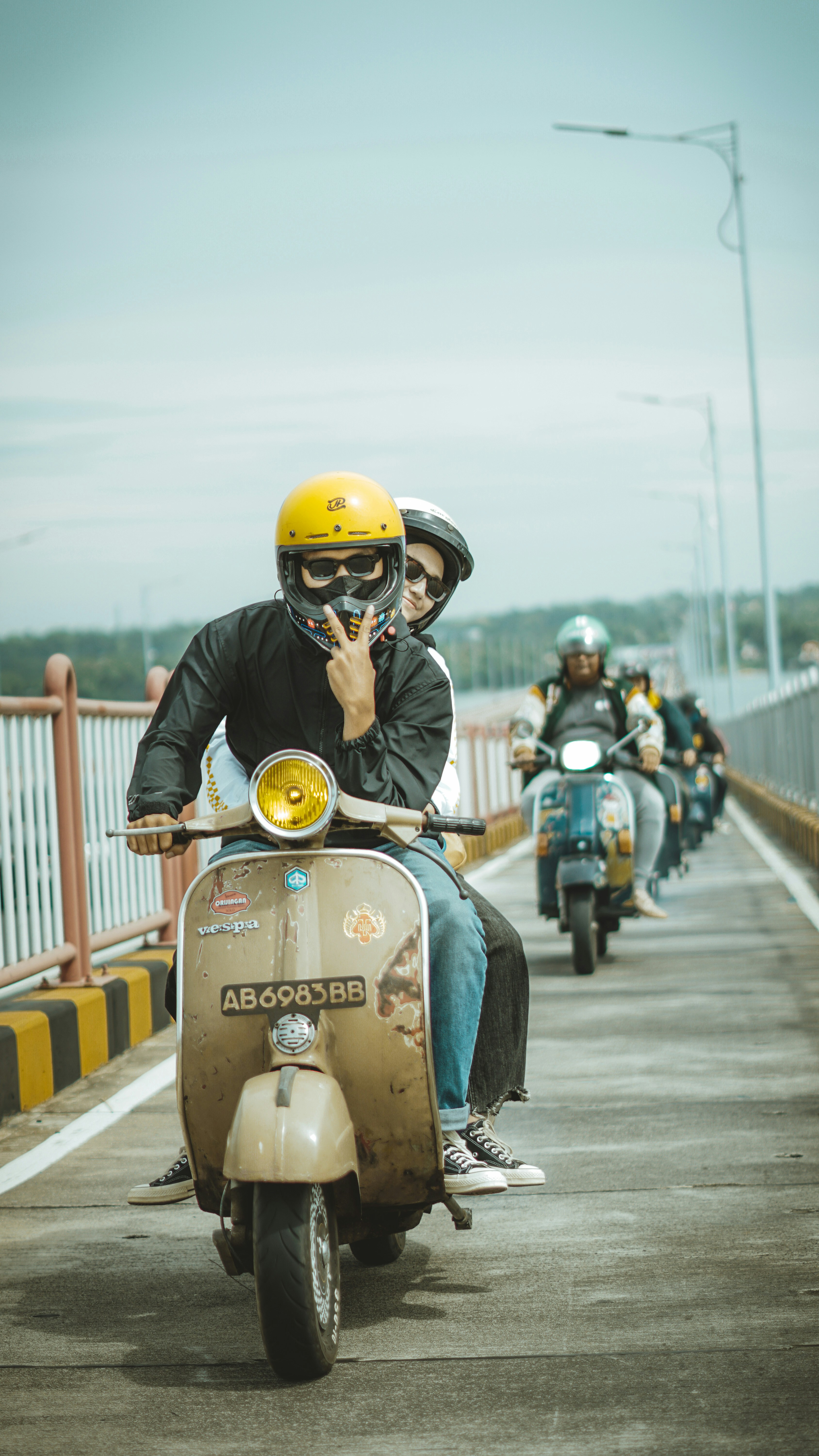 Des conducteurs de scooter traversent ensemble un pont
