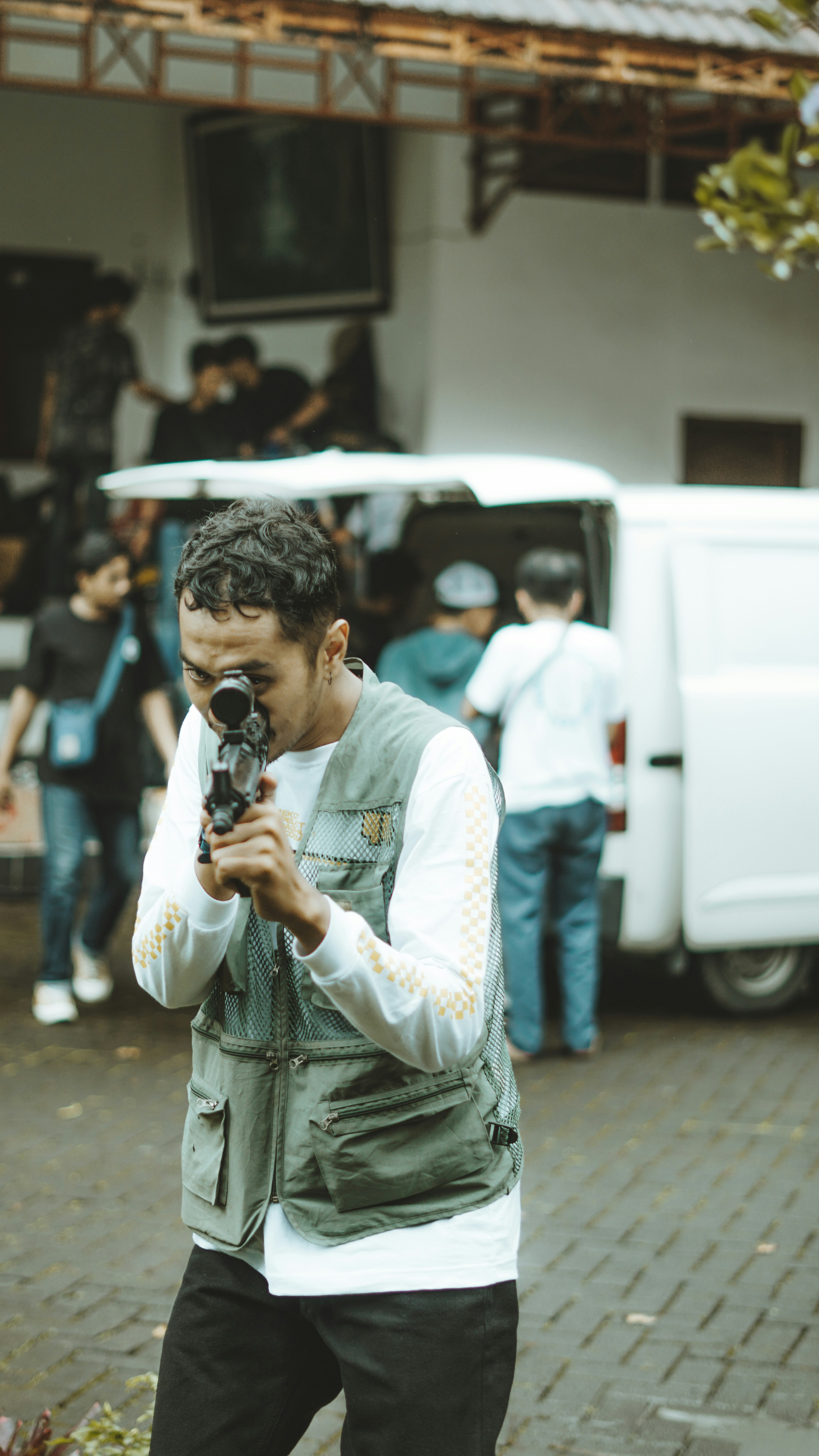 Seorang pria mengarahkan pistol ke kamera.