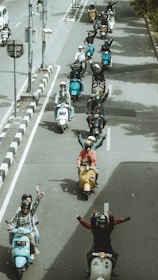 A vespa motorcycle parade on the road.