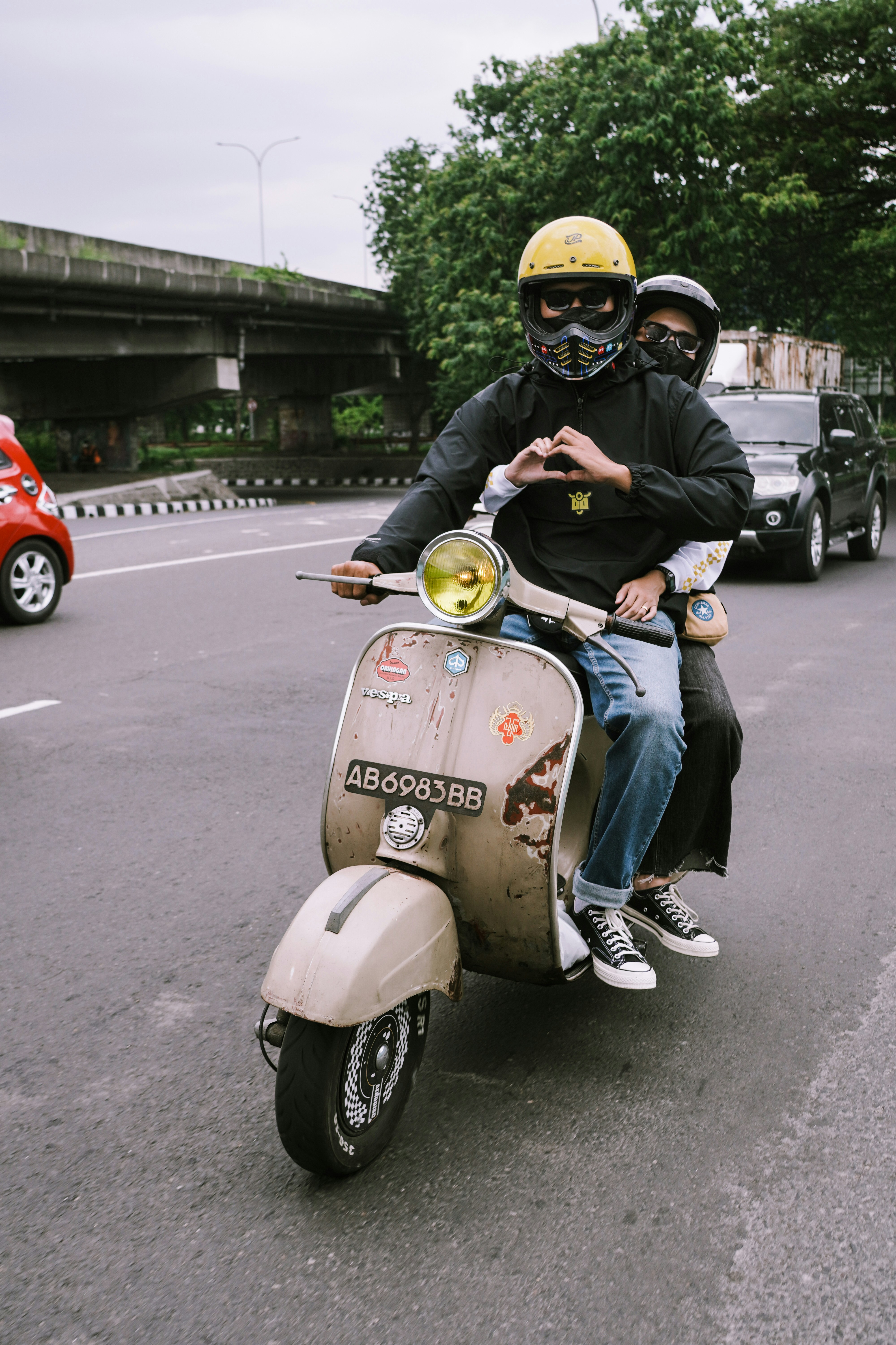 Deux personnes conduisent un scooter Vespa à l’ancienne