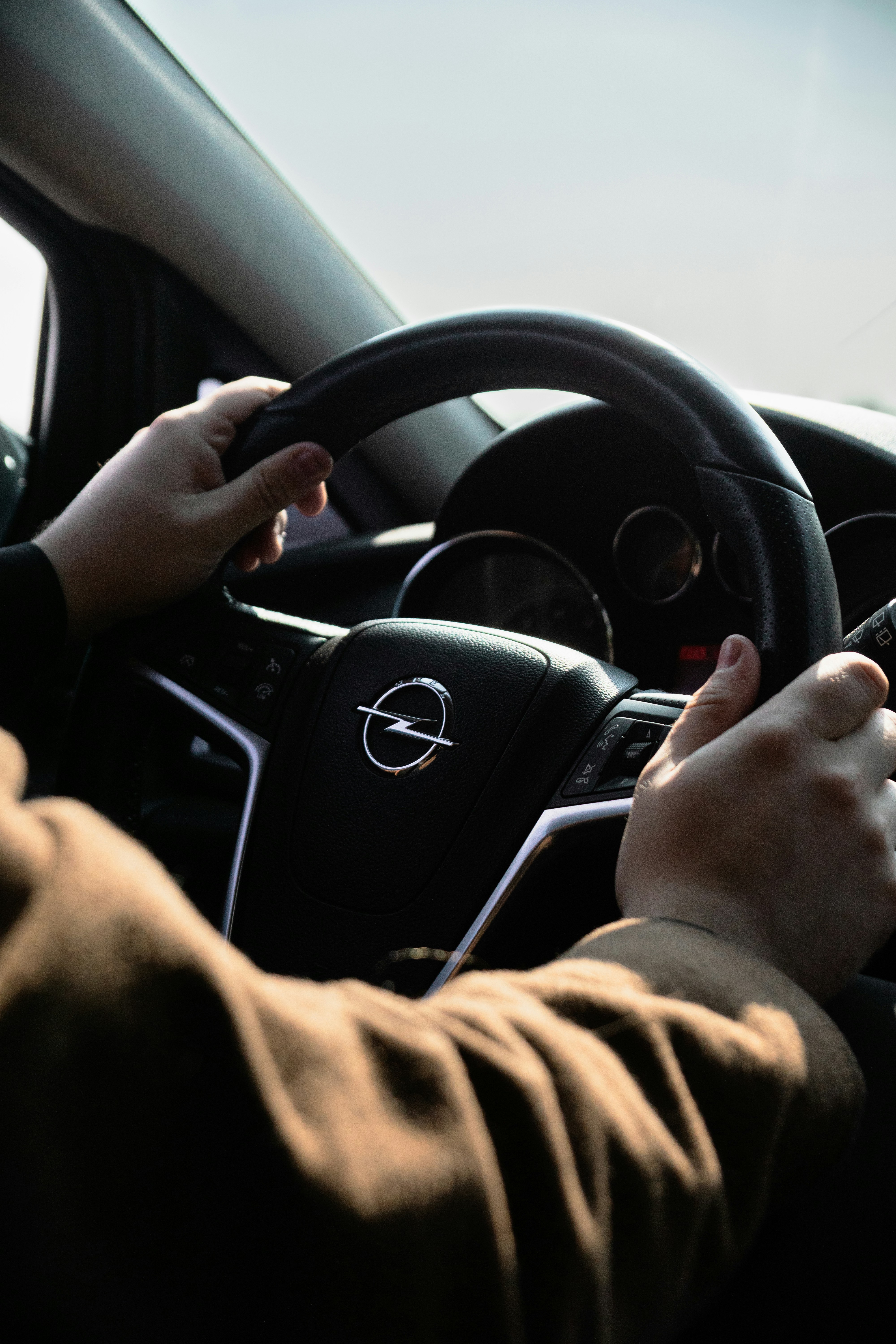 Des mains agrippent un volant Opel, prêt à rouler.