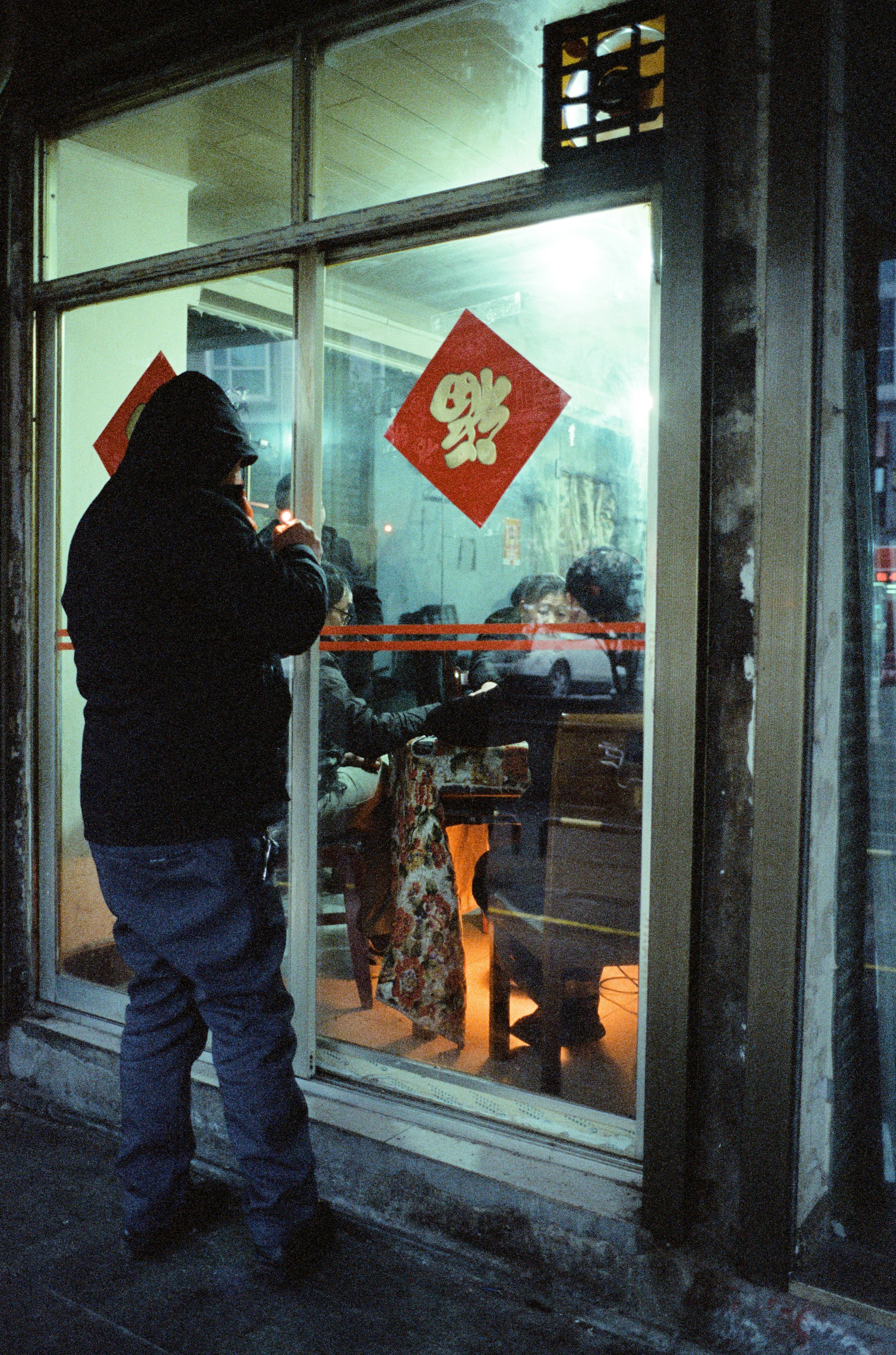 中華料理店の外でライトアップされる男性。