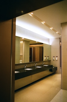 Public bathroom with sinks and large mirror.