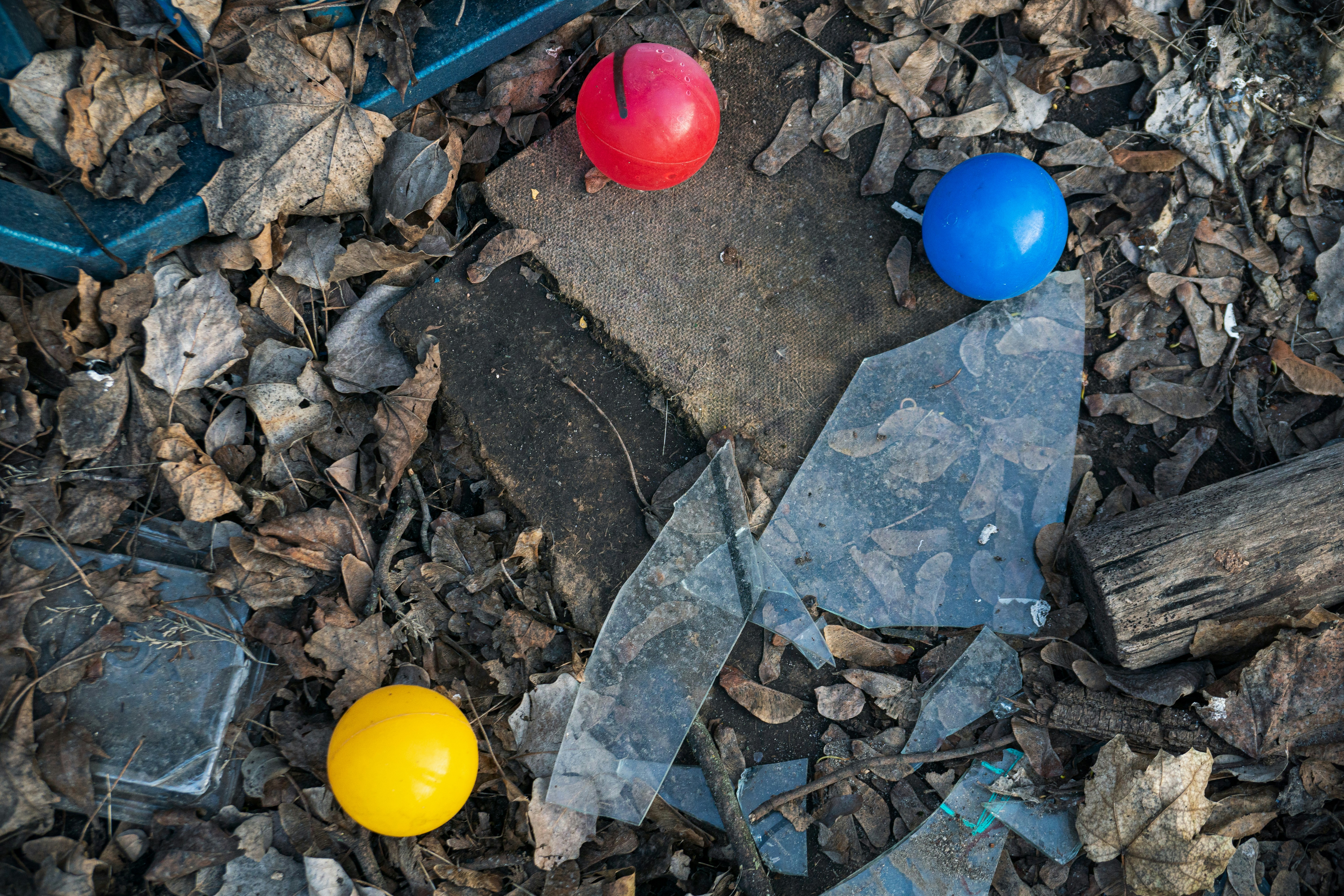 Three balls rest in littered debris.