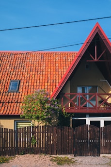 A house with a red roof and wooden fence.