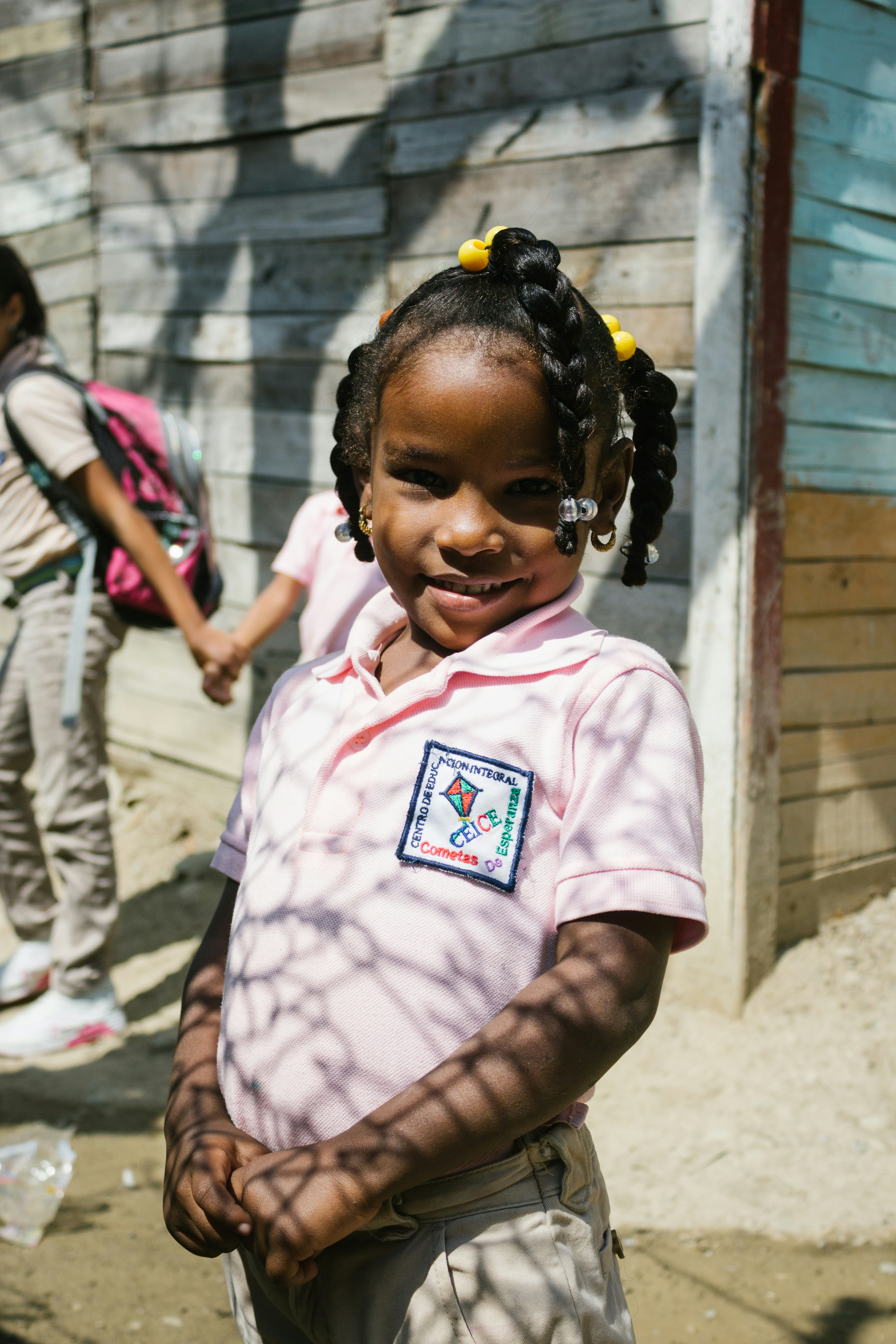 Smiling girl in uniform poses outside.