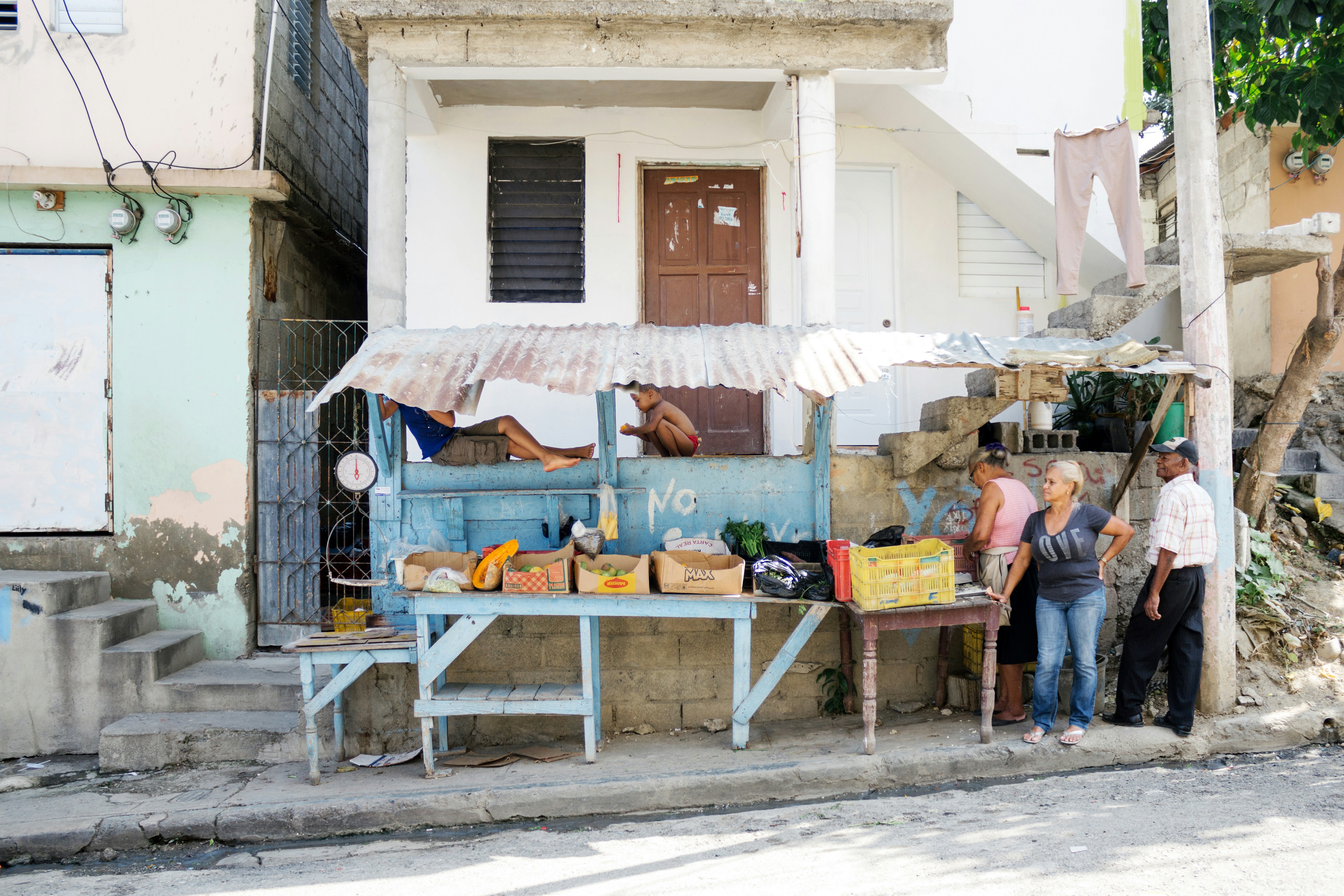 A street vendor sells fruits and vegetables.