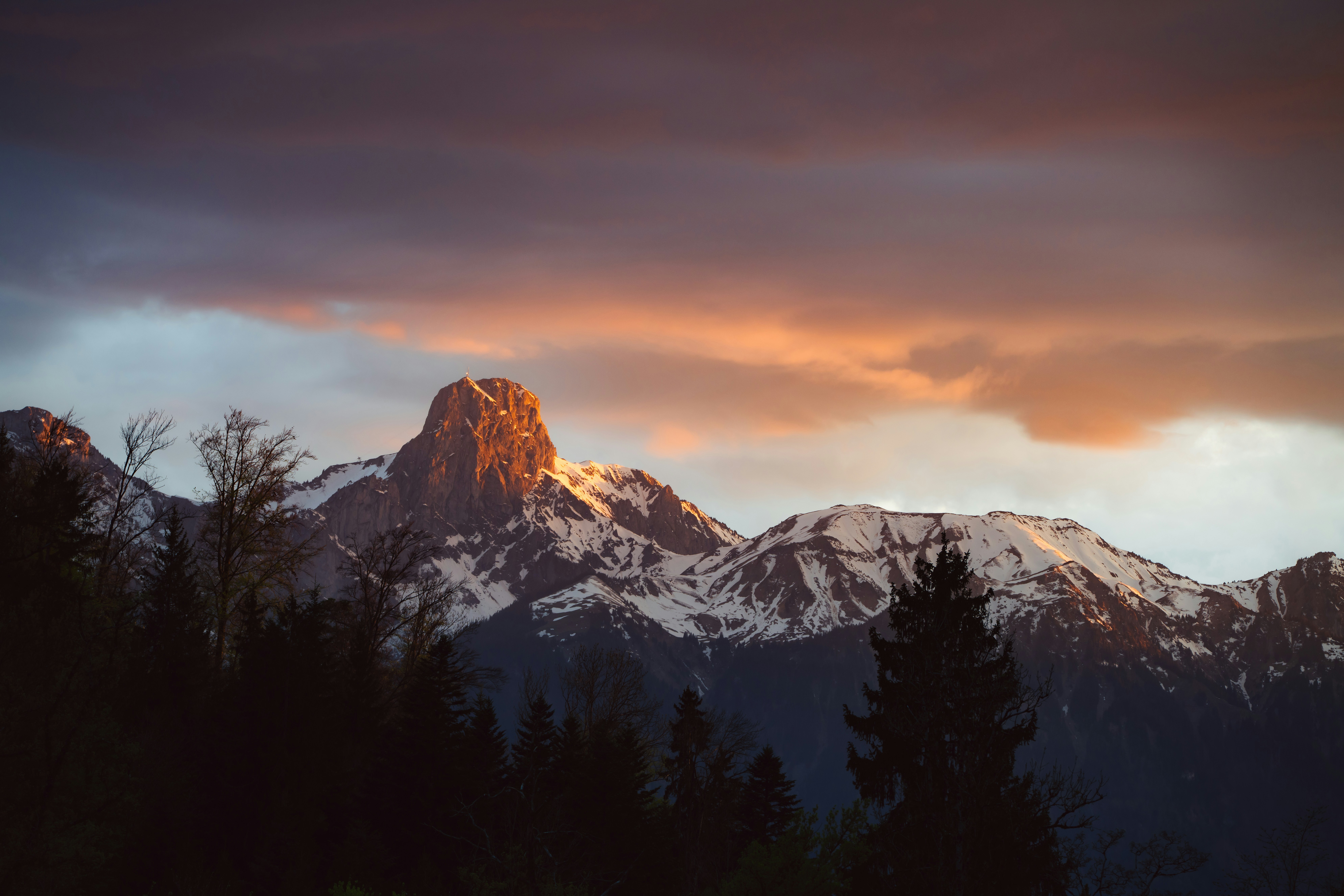 Snow-capped mountains are bathed in golden light.
